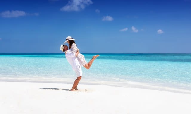 Avani+ Fares Maldives Resort couple enjoying the tropical weather and sandy beach