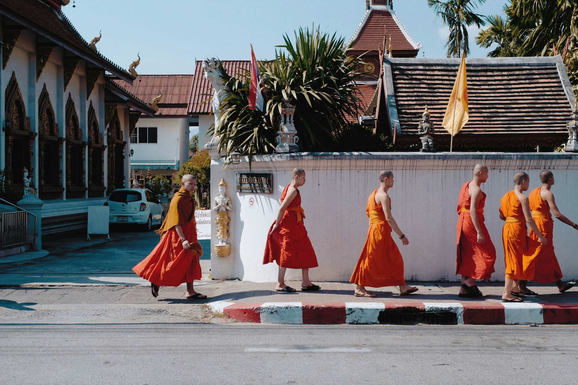 A group of young monks walking across the street.