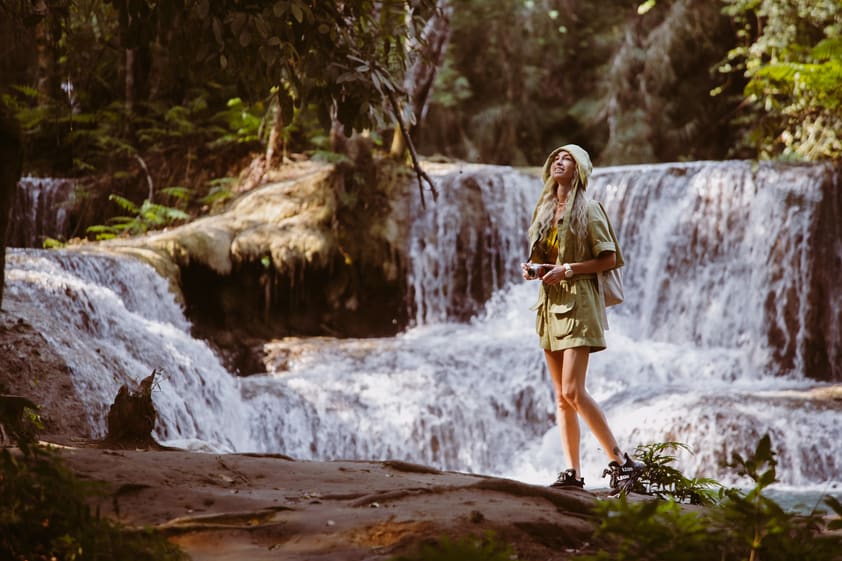 A woman admiring the Kuang Si Waterfall.