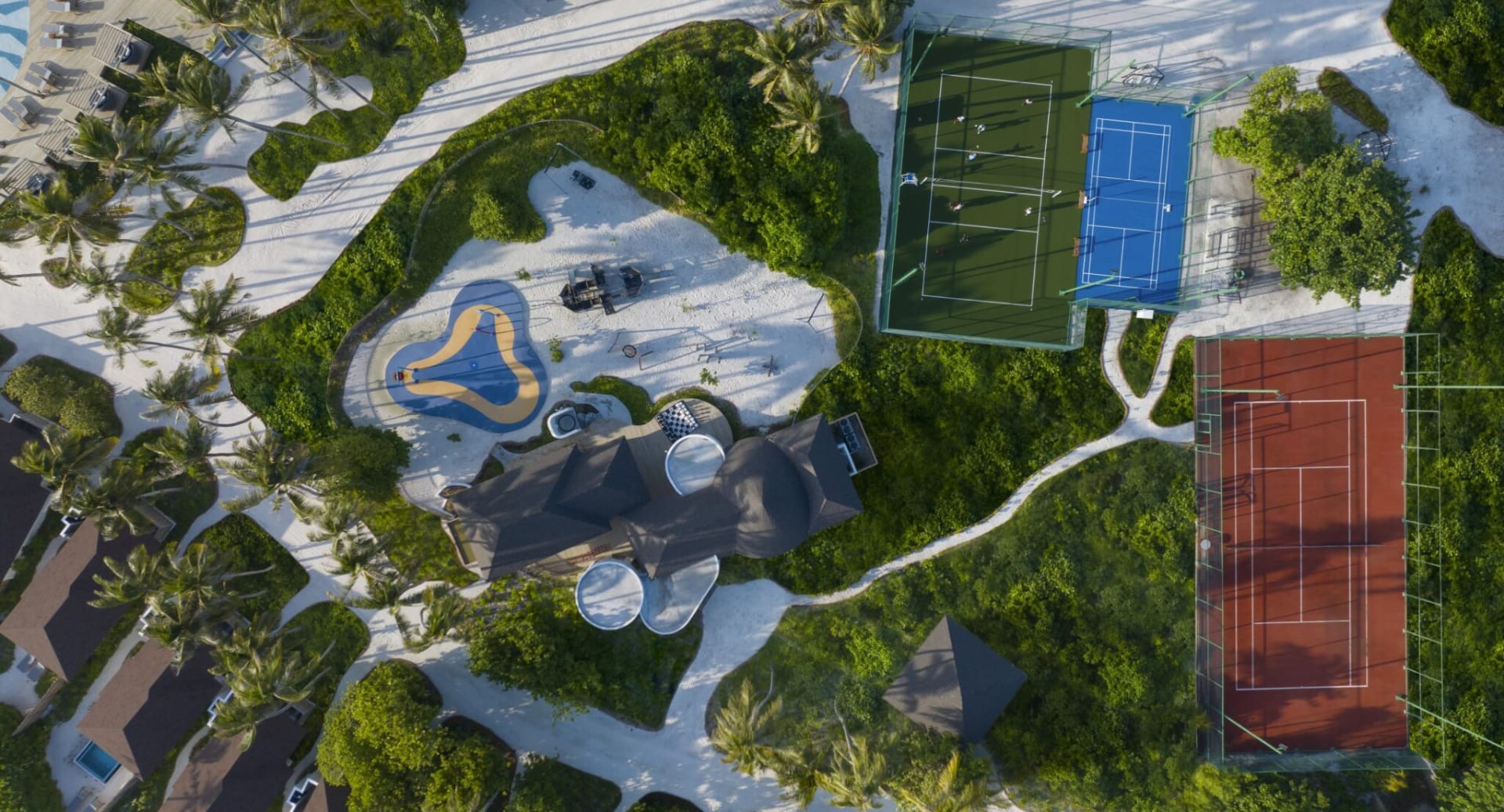 Aerial view of kids’ playground and sports courts at Avani+ Fares Maldives resort