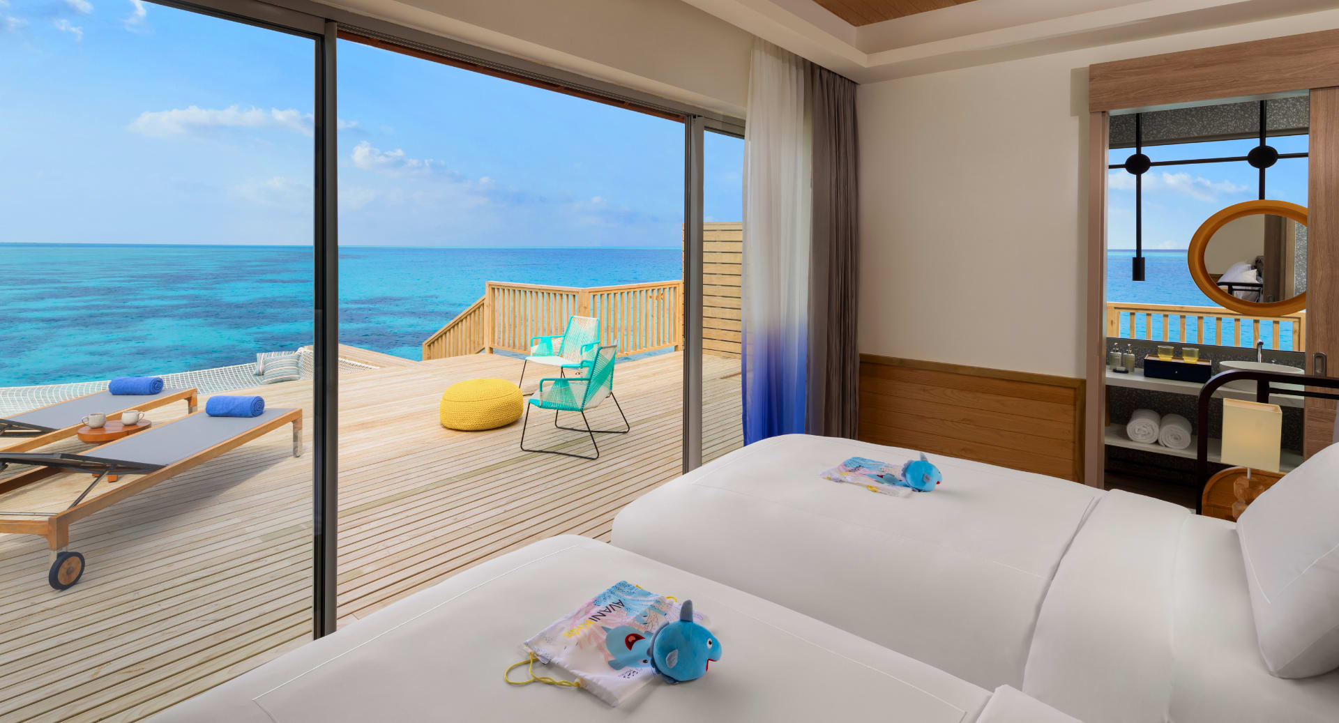 Overwater residence bedroom with ocean view and private deck at Avani+ Fares Maldives