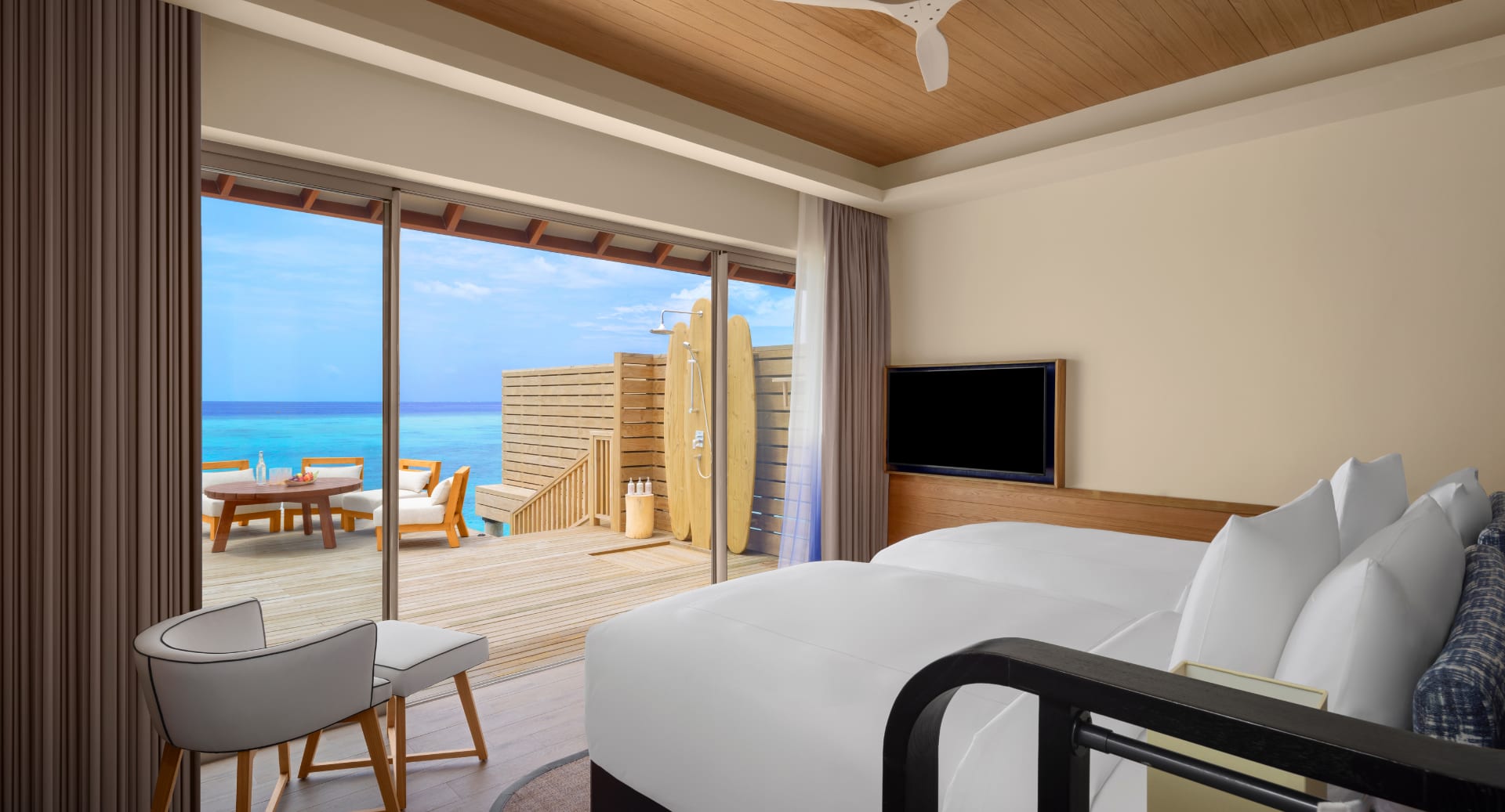 Overwater residence bedroom with ocean view and private deck at Avani+ Fares Maldives