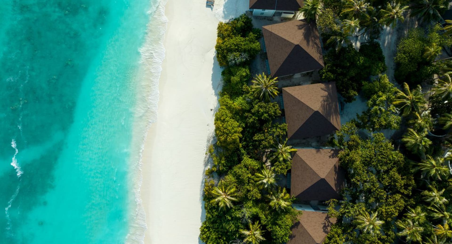 Aerial view of beachfront villas and turquoise lagoon at Avani+ Fares Maldives resort