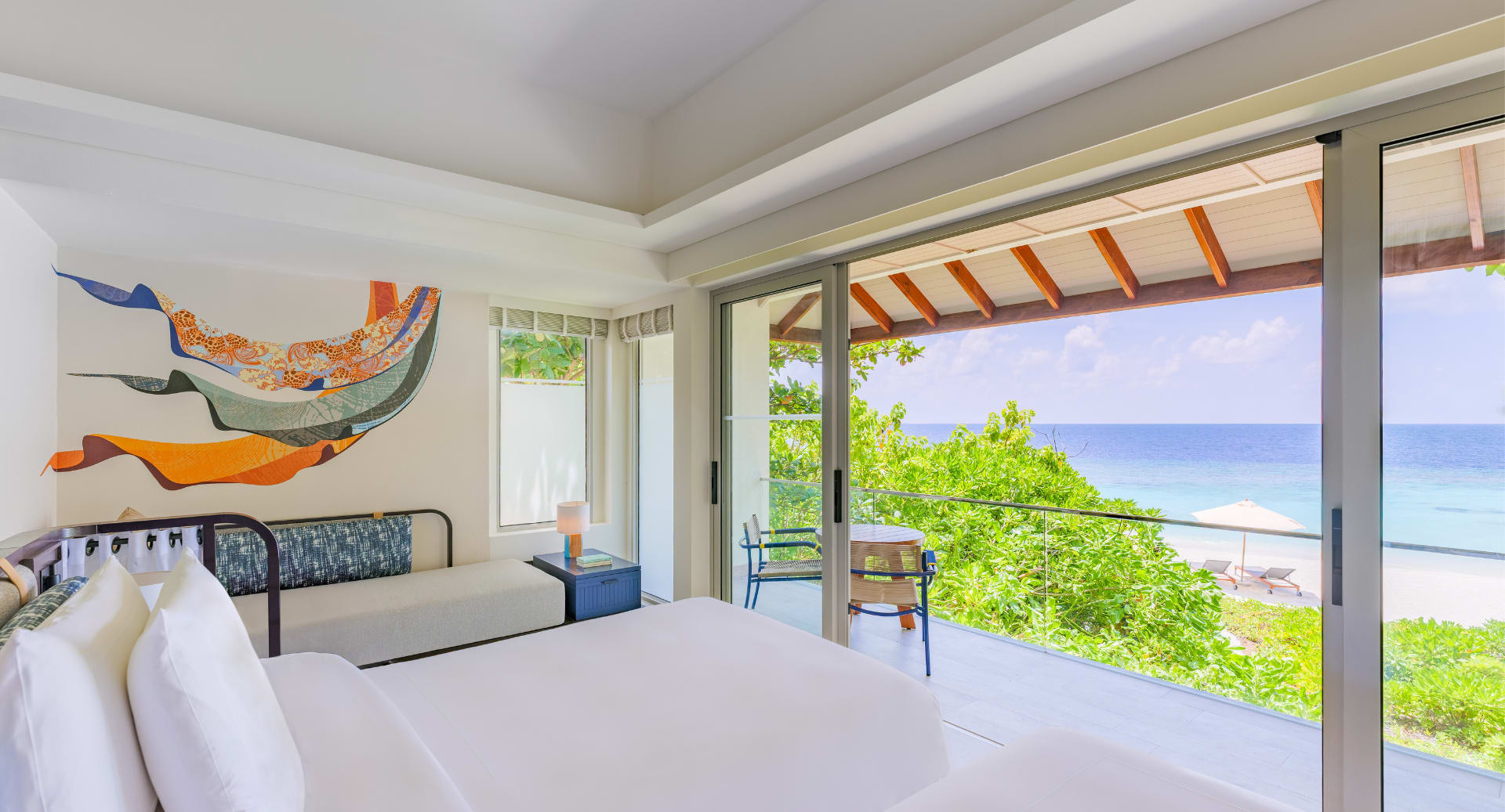 Beachfront villa bedroom with panoramic ocean view at Avani+ Fares Maldives Resort