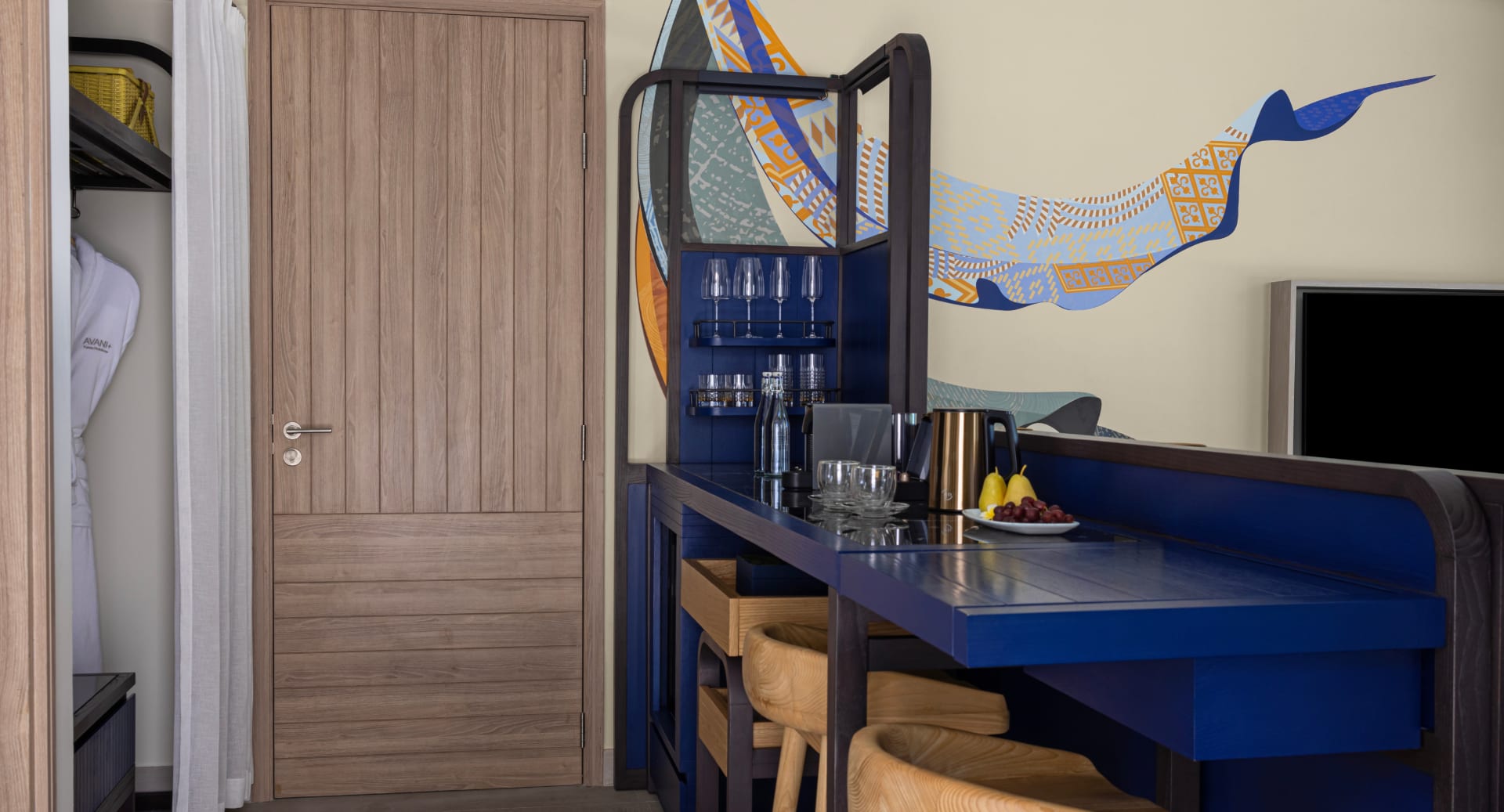 Stylish connecting villa interior featuring minibar counter and seating space at Avani+ Fares Maldives.