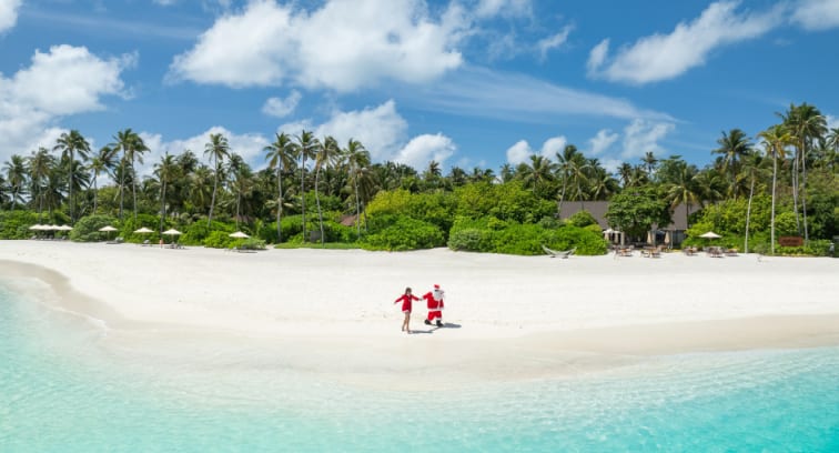 Santa sitting on an over water villa hammock overlooking the ocean at Avani+ Fares Maldives Resort
