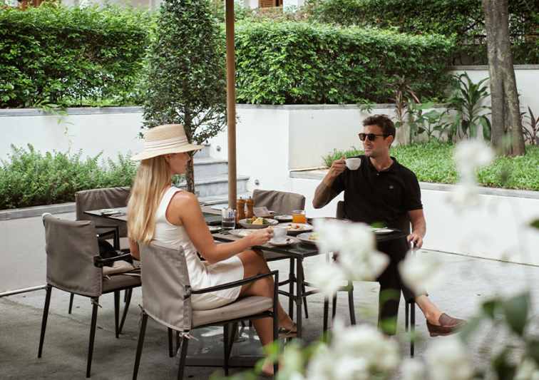 a couple having breakfast at restaurant terrace