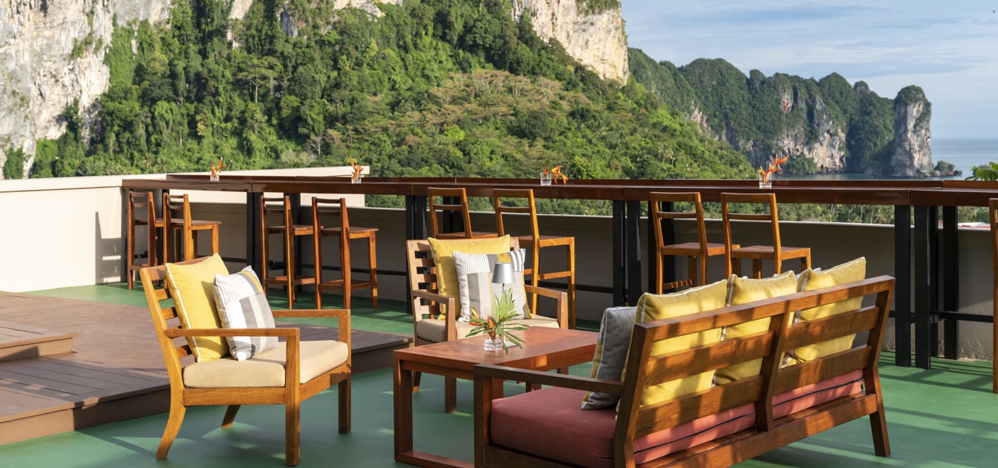 Exterior view of seating area at The Peak Bar with view of limestone mountains