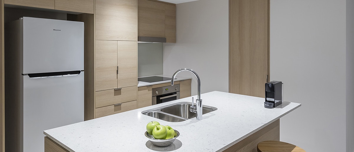 fully equipped kitchen with fridge, oven, stove top at one bedroom ocean suite AVANI Broadbeach Gold Coast Hotels