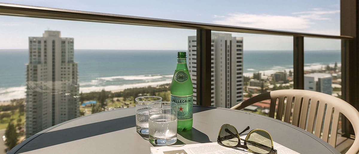 drinks and sunglasses on the table of the spacious balcony with grand ocean view at the two bedroom ocean suite AVANI Broadbeach Gold Coast Hotels