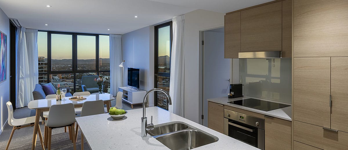 Spacious and separate kitchen, dining and living areas with beautiful city dusk view at the two bedroom suite AVANI Broadbeach Gold Coast Hotels