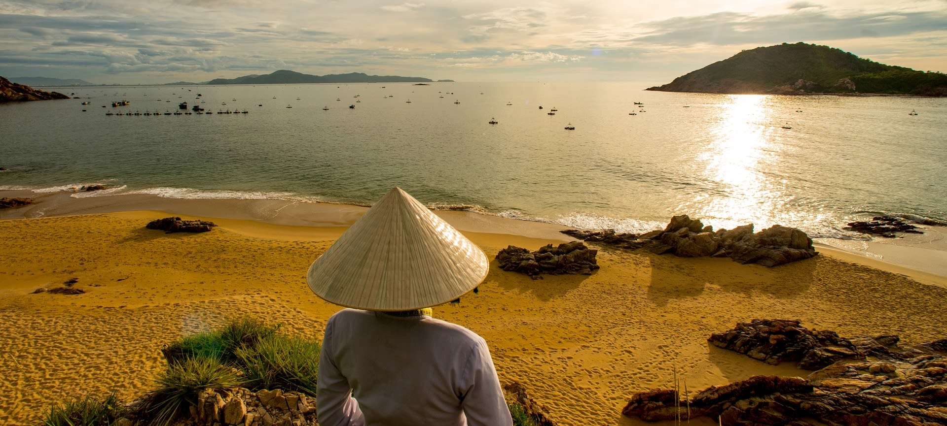 Exterior view lady in conical hat watching Quy Nhon beach sunrise